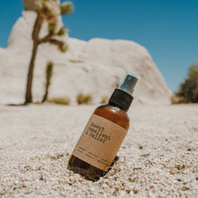 Load image into Gallery viewer, Bug spray that is an insect repellent and bug bite relief. 4 oz bottle in the dessert next to a joshua tree