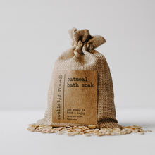 Load image into Gallery viewer, Herbal organic oatmeal bath soak in a burlap bag with some of the contents dumped out.
