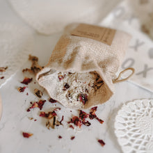 Load image into Gallery viewer, Herbal organic oatmeal bath soak in a burlap bag with some of the contents dumped out showing the oatmeal and rose petals.