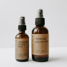 Load image into Gallery viewer, Relaxing essential oil based pillow sprays. One 2 oz amber glass bottle and one 4 oz bottle in front of a white background.
