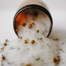 Load image into Gallery viewer, Herbal epsom salt bath in an amber jar. It is the relaxing blend with chamomile flowers, lavender buds and salt dumped out