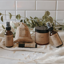 Load image into Gallery viewer, The spa gift set which includes a eucalyptus shower spray, organic lavender oatmeal bath soak, headache relief roller, essential oil &amp; herb revive bath soak and a relaxing pillow mist. The set is on a blanket in front of subway tile and eucalyptus.
