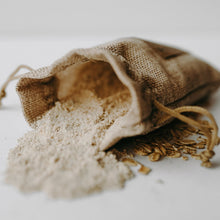 Load image into Gallery viewer, Herbal organic oatmeal bath soak in a burlap bag with some of the contents dumped out.
