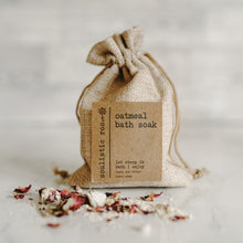 Load image into Gallery viewer, Herbal organic oatmeal bath soak in a burlap bag with some of the contents dumped out showing the oatmeal and rose petals.
