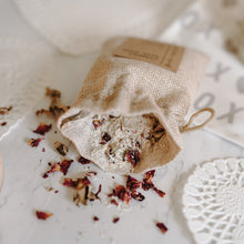 Load image into Gallery viewer, Herbal organic oatmeal bath soak in a burlap bag with some of the contents dumped out showing the oatmeal and rose petals.
