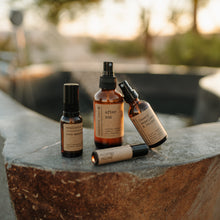 Load image into Gallery viewer, Group shot of natural products on a stonehot springs tub. Products include after sun, bug spray, allergy relief essential oil roller and sore muscle rub.
