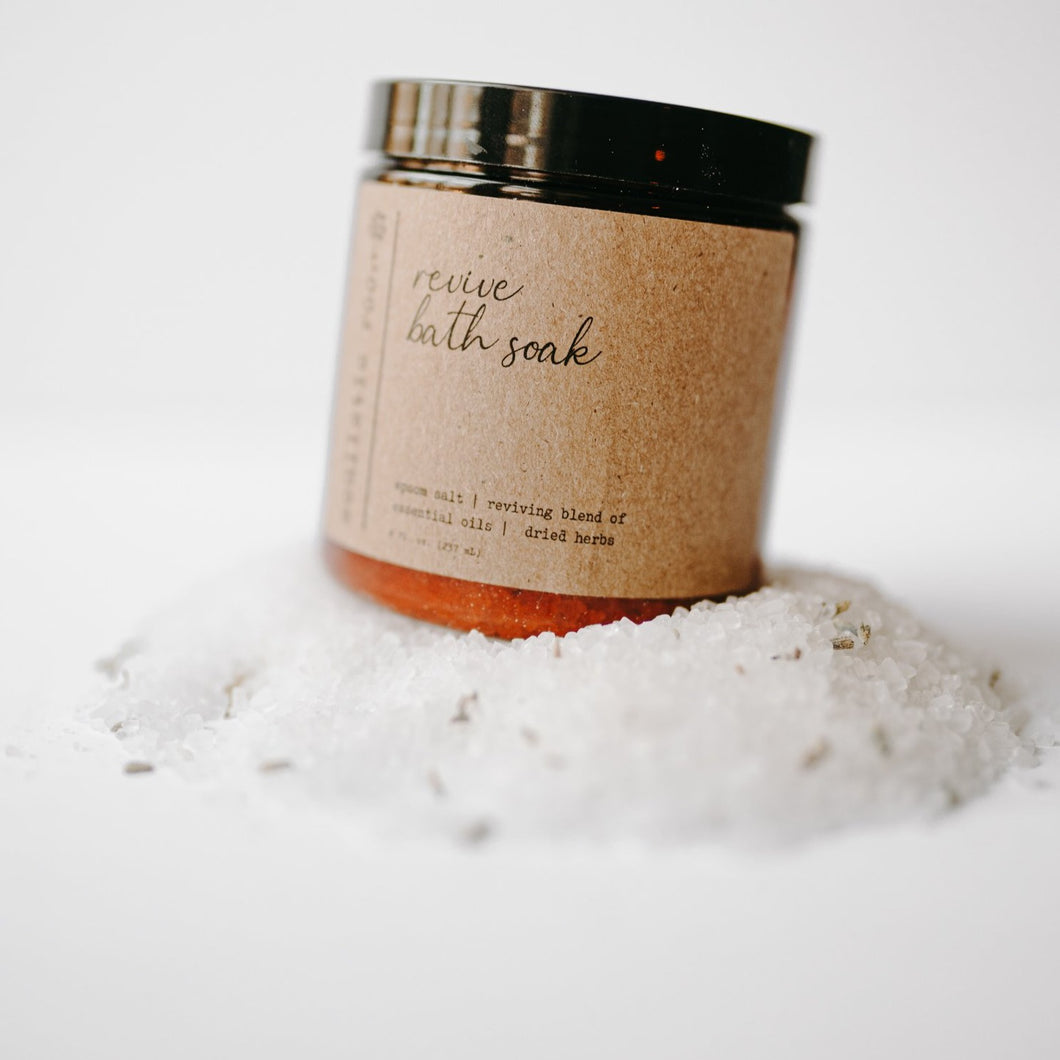 Herbal epsom salt bath in an amber jar. It is the reviving blend with eucalyptus leaves, lavender buds and salt dumped out